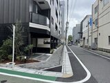 スタイリオ東品川 前面道路から見たモダンな建物外観と駐車場の様子