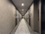 スタイリオ東品川 モダンな内装の廊下と整然と並ぶ住戸ドア