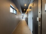 スタイリオ東品川 共用廊下を奥へ向けて撮影した、落ち着いた色合いの内廊下空間