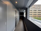 スタイリオ東品川 モダンな共用廊下から見た採光窓と隣接する建物の様子