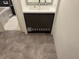 スタイリオ東品川 黒いキャビネット付きの洗面台とグレーの床材が落ち着いた洗面室