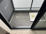 スタイリオ東品川 エレベーター内部から見た落ち着いた色合いの床材と黒枠の天井