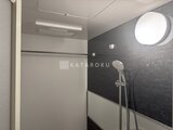 スタイリオ東品川 モダンなデザインのバスルーム、黒い壁面と丸窓が特徴