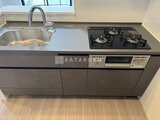 スタイリオ東品川 グレーの天板にシンクとガスコンロを備えたキッチン