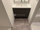 スタイリオ東品川 モダンな黒い洗面台と落ち着いた色合いのタイル張り洗面室
