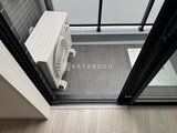 スタイリオ東品川 バルコニーへ続く開放的なテラス窓と室外機のある空間