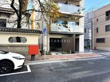 グランカーサ上野松が谷 街路樹を挟んで見た建物の駐車場エントランス付き外観
