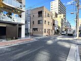 グランカーサ上野松が谷 前面道路から見た建物外観と周辺の街並み