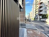 グランカーサ上野松が谷 前面道路から見た建物エントランスと周辺街並み