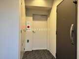 グランカーサ上野松が谷 明るい照明の共用廊下とダークカラーのドア