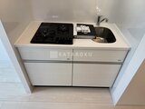 グランカーサ上野松が谷 ガスコンロと シンクを備えたコンパクトなキッチン