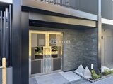 エレミ本蓮沼 モダンな外観に灯りが入るガラス引き戸のエントランス
