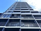 エレミ本蓮沼 下から見上げた現代的なマンション外観と各階のバルコニー