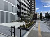 エレミ本蓮沼 建物前面の開放的なエントランスと植栽が配置された広場