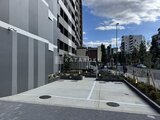 エレミ本蓮沼 開放的な駐車場から見た建物の外観と周辺街並み