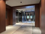 エレミ本蓮沼 暖色系の木調パネルに囲まれた開放的なエントランスホール