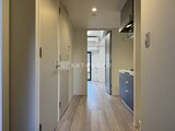 エレミ本蓮沼 玄関から奥へ続く廊下とコンパクトなキッチンスペースの様子