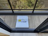 エレミ本蓮沼 開放的な天井のルーバーから光が差し込むバルコニー空間