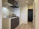 エレミ本蓮沼 モダンなキッチンスペースと廊下を見渡した居住空間