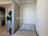 エレミ本蓮沼 間仕切りで分かれたベッドスペースとキッチンの様子