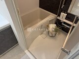 エレミ本蓮沼 浴室全体を写した、落ち着いた色合いの浴槽とシャワーブース