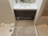 エレミ本蓮沼 白いカウンター天板と暗色収納が備わった洗面化粧台