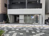 シーフォルム板橋3 モダンな外観の建物1階エントランスと幾何学模様の舗装