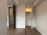 シーフォルム板橋3 複数の収納とダークドア、明るい窓を備えた廊下