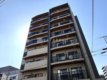 ハイズ三ノ輪2 青空を背景に捉えた、バルコニー付きの落ち着いた印象の建物外観