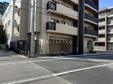 ハイズ三ノ輪2 前面道路から見たモダンな建物の外観と駐車場入口