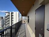 ハイズ三ノ輪2 開放的な共用廊下から街並みを望むバルコニーの様子