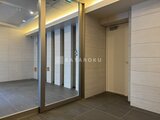 ハイズ三ノ輪2 落ち着いた色調のタイル張りトイレ入口と廊下の様子