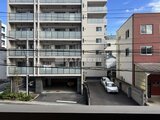 ハイズ三ノ輪2 駐車場とエントランスが見える建物の外観と周辺の様子