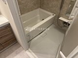 ハイズ三ノ輪2 白い浴槽とベージュ色のタイル張りの落ち着いた浴室