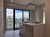 ハイズ三ノ輪2 バルコニーへ繋がる大きな窓から街並みが見える開放的なキッチン