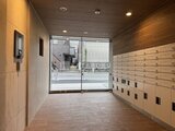 グランパセオ押上八広 木調の壁と郵便受けが配置された明るいエントランスホール
