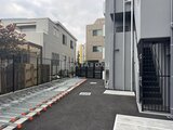 グランパセオ押上八広 駐車スペースと隣接建物が見える共用通路の様子