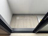 グランパセオ押上八広 黒いドアフレームから見た落ち着いた木目調フロアの玄関スペース