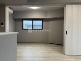 グランパセオ押上八広 明るい床材のリビングダイニングと対面キッチン