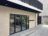 コンフォリア・リヴ駒込西ヶ原 モダンな外観のエントランス、黒枠ガラス戸から見た庭園