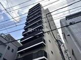 コンフォリア・リヴ駒込西ヶ原 明るい空の下、黒いバルコニーが印象的な中層マンション外観
