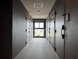 コンフォリア・リヴ駒込西ヶ原 明るい採光が入る共用廊下とモダンデザインの玄関ドア