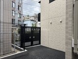 コンフォリア・リヴ駒込西ヶ原 開放的なエントランスアプローチ、黒い門扉と明るいタイル壁