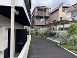 コンフォリア・リヴ駒込西ヶ原 駐車スペースから見た共用庭園と周辺建物の様子