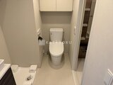 コンフォリア・リヴ駒込西ヶ原 トイレ上部の収納棚と温水洗浄便座付きのコンパクトなトイレ室