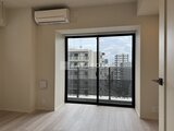 コンフォリア・リヴ駒込西ヶ原 落ち着いた色調の洋室に設置された大きな窓と室外機