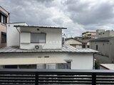 コンフォリア・リヴ駒込西ヶ原 住宅街に建つ白い外壁の建物を隣地から見た様子