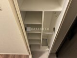 コンフォリア・リヴ駒込西ヶ原 複数の棚板を備えた白い壁面収納スペース