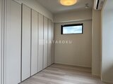 コンフォリア・リヴ駒込西ヶ原 大きなクローゼットと高窓の光が入る落ち着いた寝室