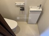 コンフォリア・リヴ駒込西ヶ原 タンクレストイレと手洗いシンク付きのモダンなトイレ空間